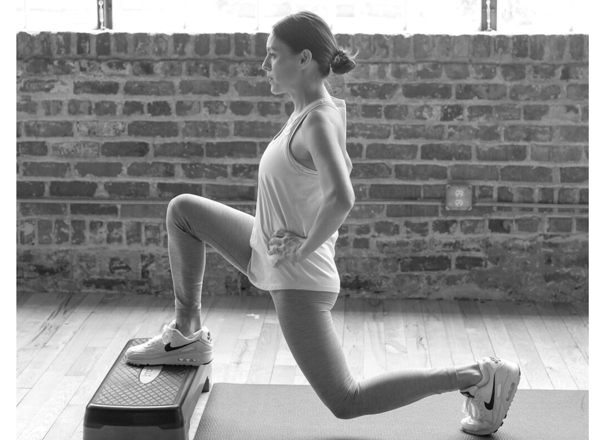 Side image of a woman doing a lunge with her front foot on a low bench