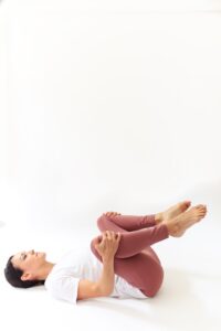 woman demonstrates double knee to chest stretch 