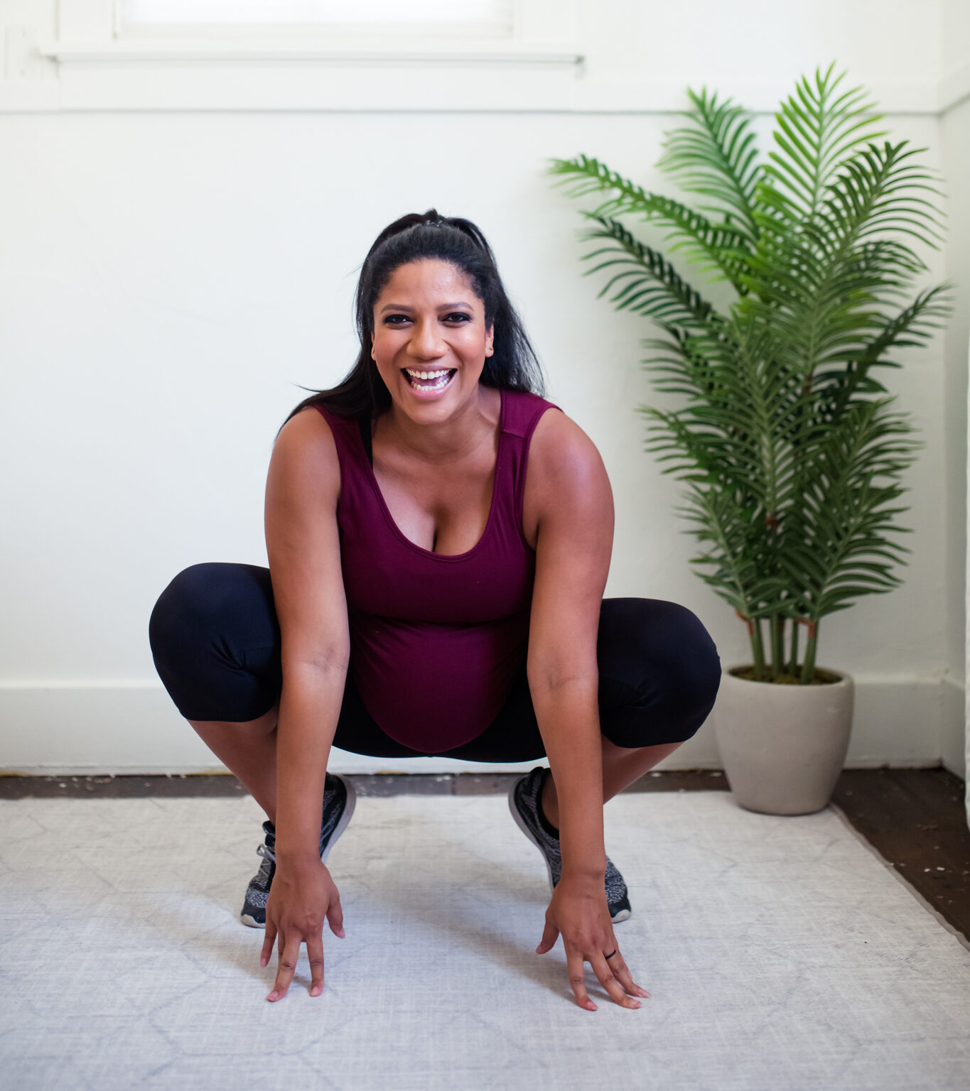 Woman squatting & smiling