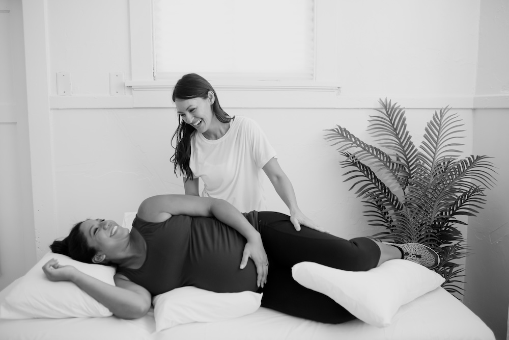 therapist helping pregnant patient