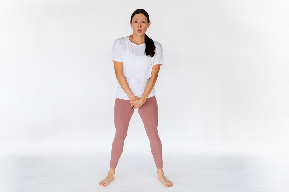 Woman holding crotch looking pained