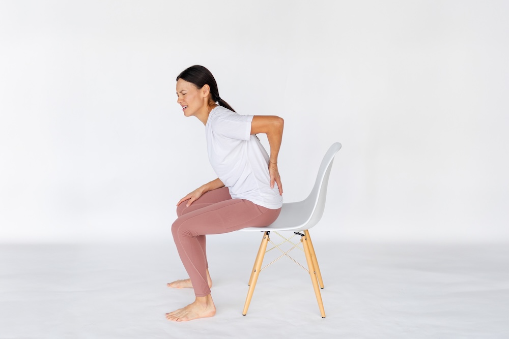 woman sitting on a chair with back pain ehlers danlos syndrome treatments